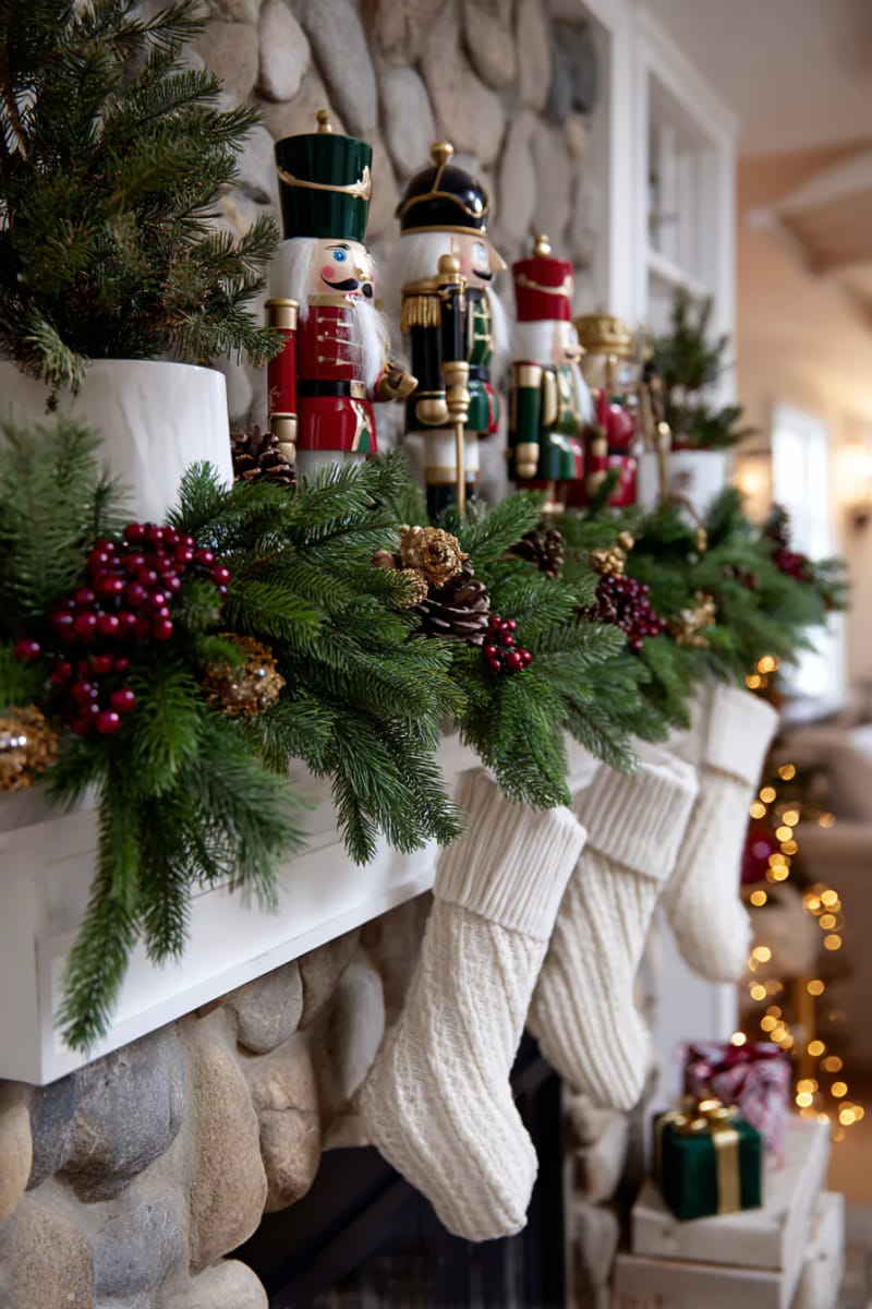 fireplace mantle with cascading pine garland and vintage nutcrackers 1