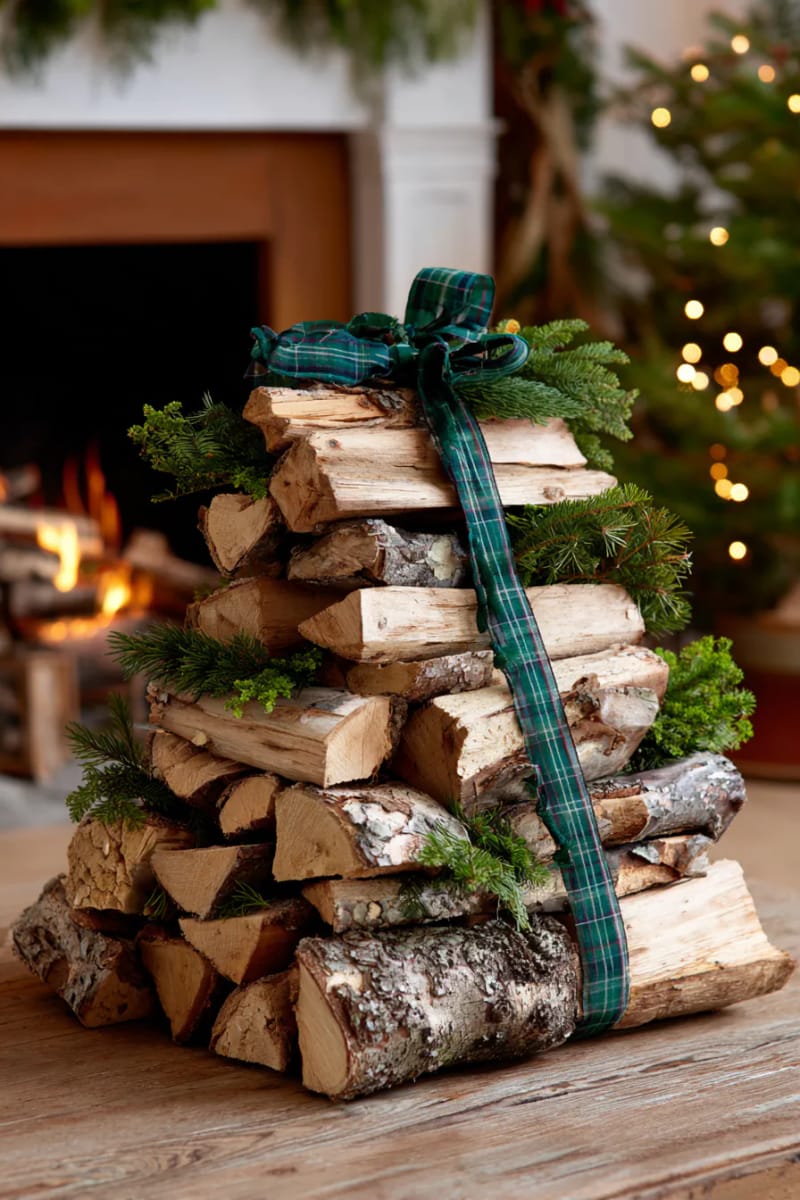 25 Green Christmas Fireplace Decor Ideas for a Fresh and Festive Mantel 47 firewood stack styled with spruce branches and green plaid ribbon 1