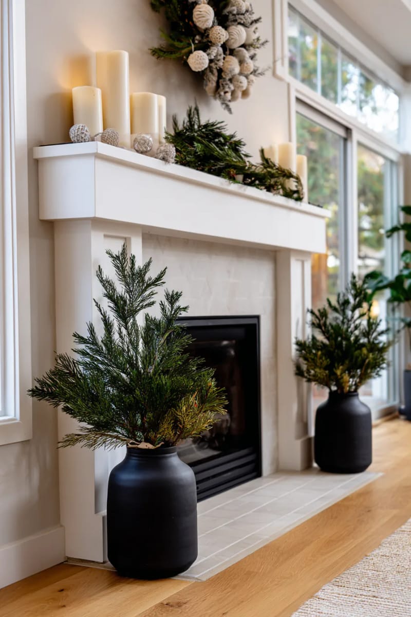 25 Green Christmas Fireplace Decor Ideas for a Fresh and Festive Mantel 23 minimalist pine branches in matte black vases flanking the fireplace 1