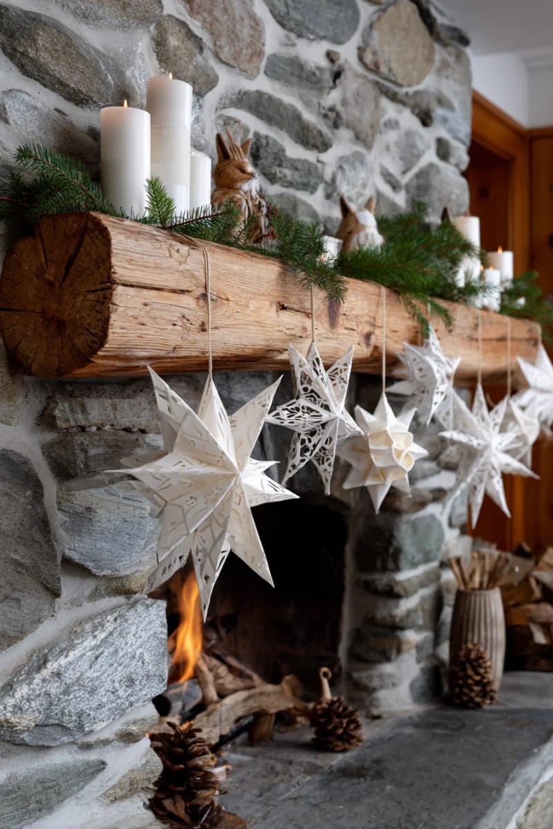 nordic-inspired paper star garland draped across a rustic fireplace 1