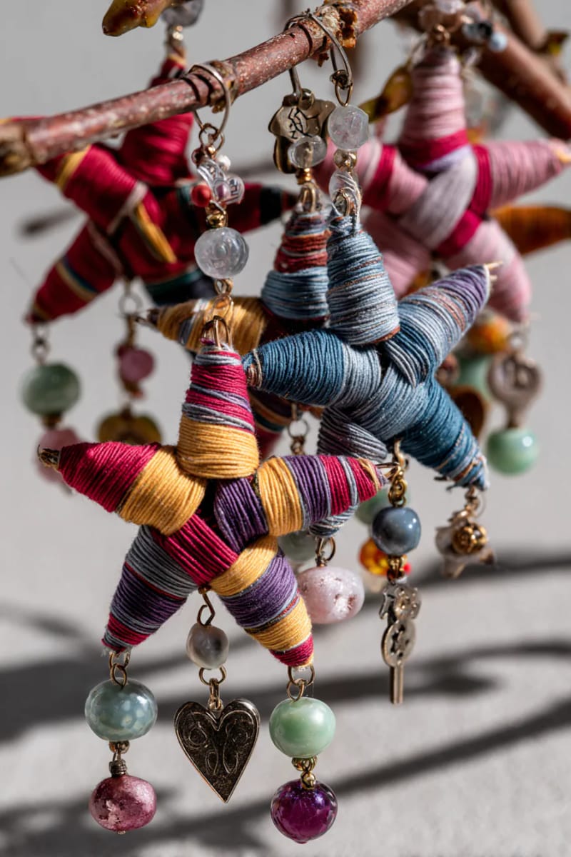 29 Upcycled Christmas Crafts For Unique Holiday DIY Projects 42 yarn-wrapped stick stars adorned with upcycled beads and charms 1