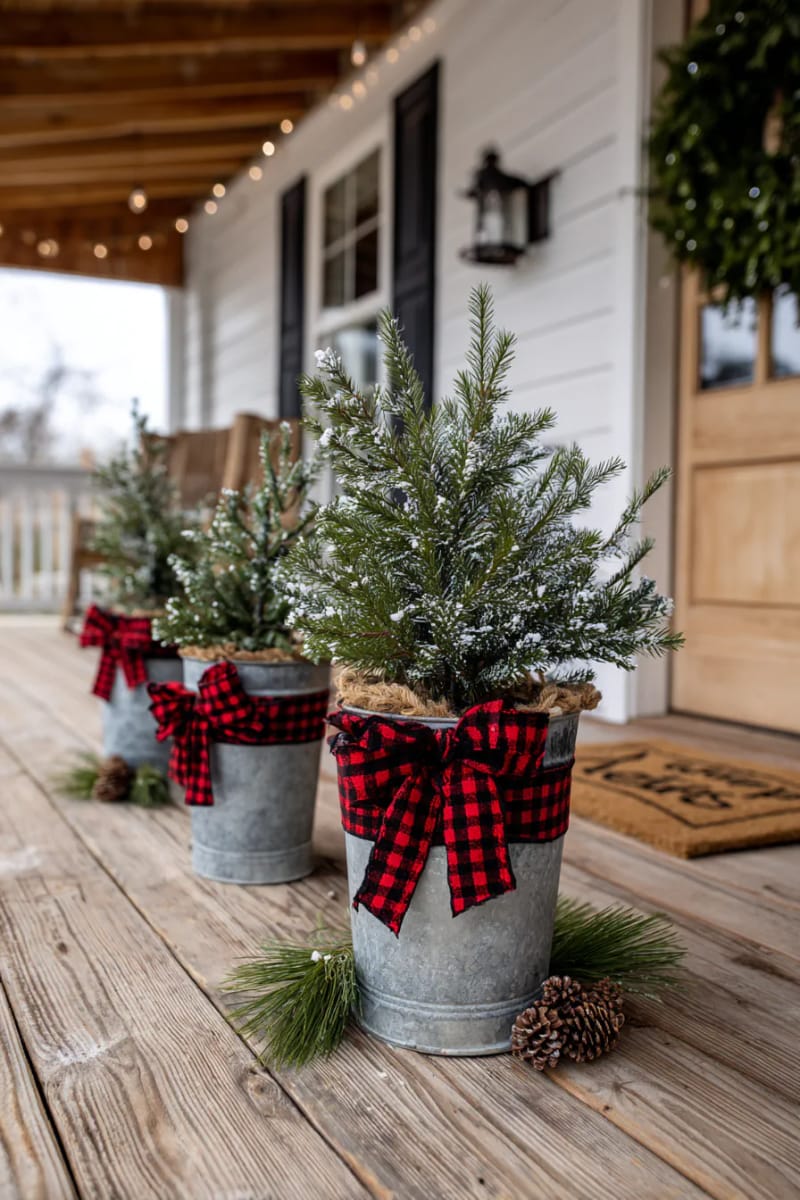 15 Simple Farmhouse Christmas Front Porch Decor Ideas 5 mini pine tree cluster in galvanized farmhouse buckets with plaid ribbon bows 1