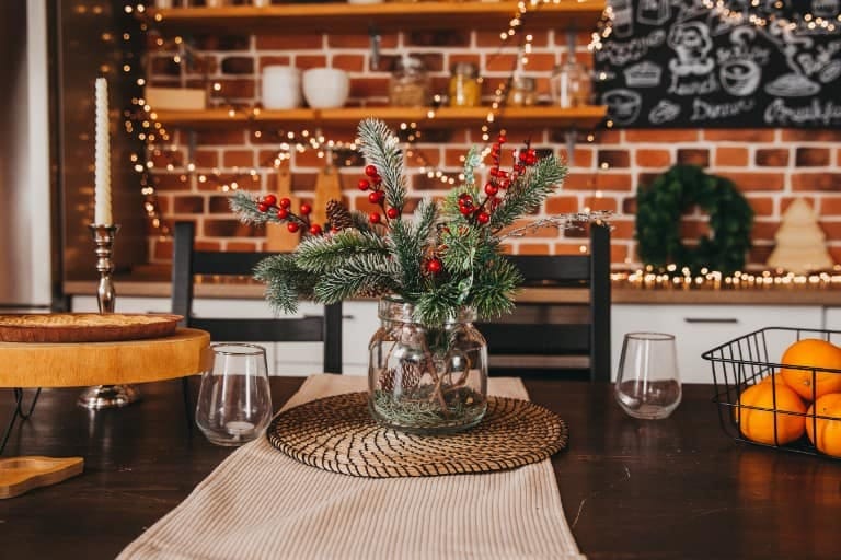 11 Mason Jar Christmas Centerpieces That Let the Greenery Do the Work 22 a low runner of small jars for a narrow table 1