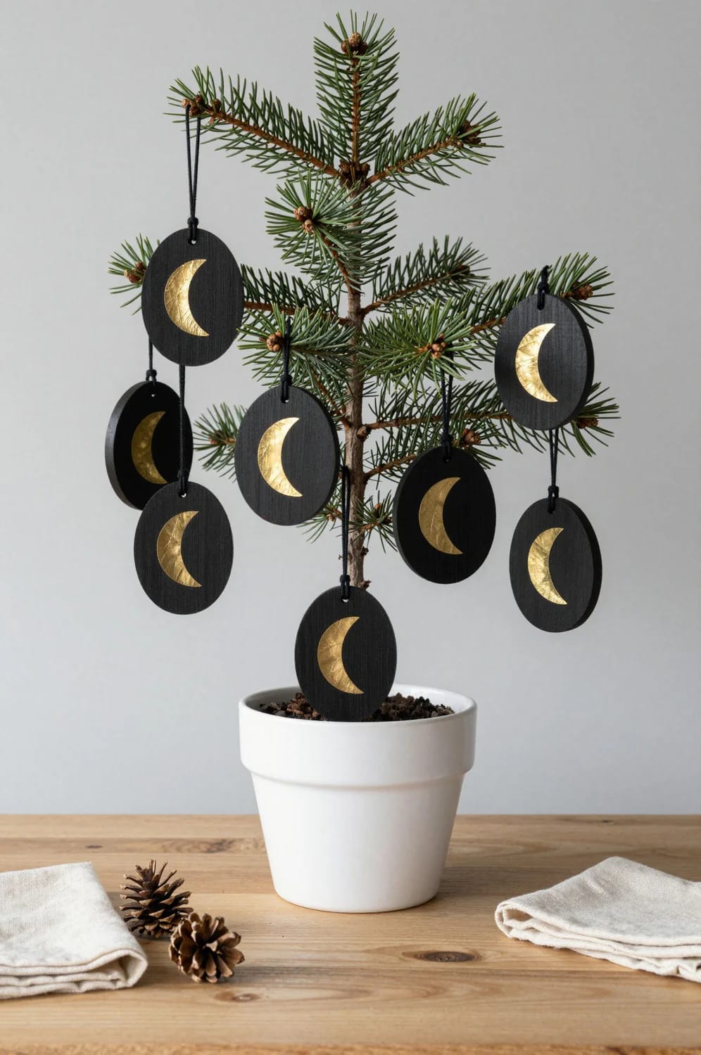 13 Painted Wood Slice Ornaments for a Minimalist Tree 14 matte black slices with a brass-leaf moon 1