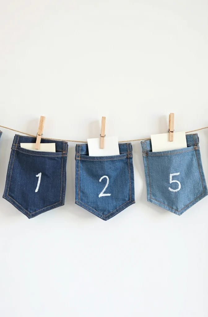Jean Pocket Gift Card Holder Ideas Three denim jean pockets labeled 1, 2, and 5 hang from a clothesline with clothespins, each holding a white card for a group gift card holder display.